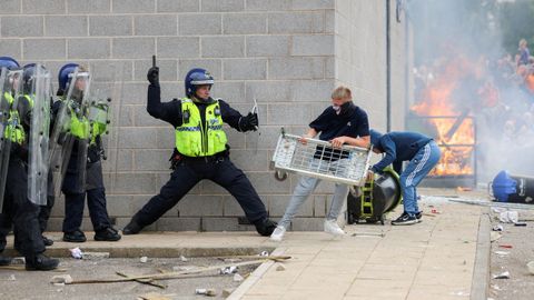 Un agente de polica se enfrenta a un manifestante en los alrededores de un hotel que alberga a simpapeles, en Rotherham.