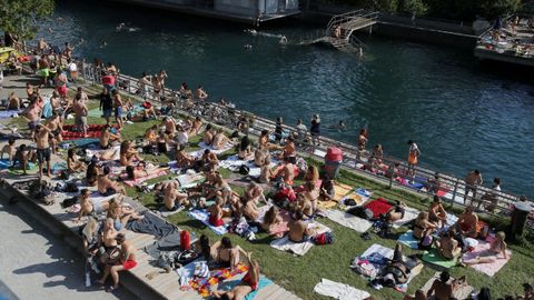 Numerosas personas disfrutan de un d�a soleado en el r�o Limmat, en Z�rich