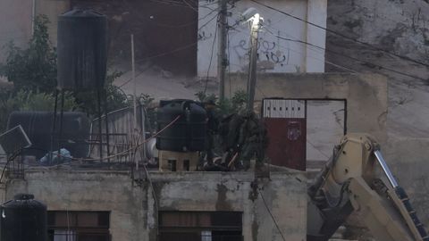 Soldados arrastran el cadver de un palestinos en la terraza de un edificio de Qabatiya, al sur de Yenn.