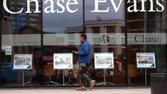 Un viandante camina ante el escaparate de una agencia inmobiliaria en Londres.