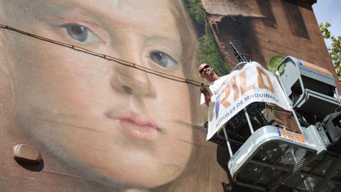 El muralista catal�n Uri, en la cesta desde la que ha pintado una pared lateral del IES Canido, el domingo