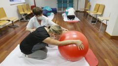 La fisioterapeuta Beatriz Freire atiende a una paciente en la escuela de espalda de la nueva unidad del Fontenla Maristany