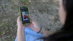 Una mujer brasile�a muestra una de las fotos de ella que hicieron con Grok