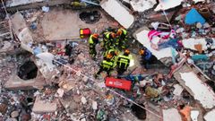 Equipos de rescate trabajan entre los escombros de un edificio de La Guaira, Venezuela