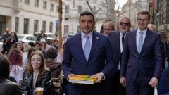George Simion camina por una calle de Bucarest con el ex primer ministro polaco Mateusz Morawiecki.