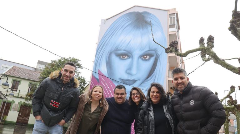La comisión de fiestas de Perlío ante el mural de Raffaella Carrá