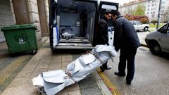 Operarios de la funeraria sacan uno de los cuerpos