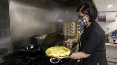 Evangelina Rey sacando su tortilla del fuego en junio del 2021.
