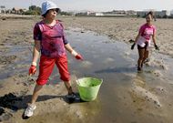 Una mariscadora se endereza: trabajan a mano, doblando la espalda, para unos ingresos m�nimos.