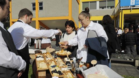 Alumnos sirviendo la mesa de quesos del cctel del evento