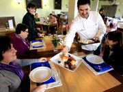 Miguel Rodr�guez, jefe de cocina en Tui, sirve el almuerzo a los comensales.