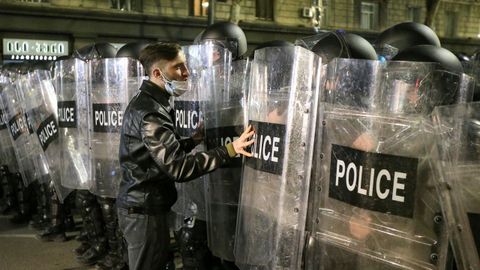 Un manifestante intenta hablar con los policas antidisturbios.