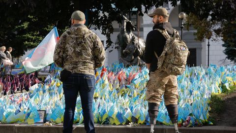 Un exsoldado ucraniano que perdi� ambas piernas observa las banderas colocadas en la plaza de la Independencia de Kiev para recordar a los soldados ca�dos.