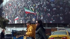 Iran�es caminan por un mural patri�tico en una calle de Teher�n.