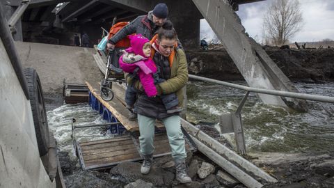 Civiles con nios huyendo de Irpn, en medio de un puente destrozado 