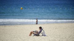 Una mujer tomando el Sol ayer en la playa de Silgar (Sanxenxo)