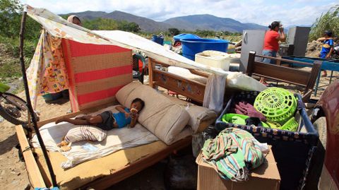 Cientos de colombianos cargan sus pertenencias por el río Táchira desde Venezuela hacia Colombia.