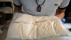 Un miembro de Sinaloa en acci�n. La foto es del 2022 y retrata a un narco en una casa de Culiac�n mostrando un paquete de metanfetamina preparado para enviar su destino