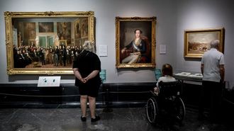 Tres asistentes observan varias obras en el Museo del Prado, en Madrid. 