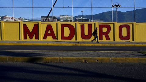 Un hombre pasa junto a un mural de Maduro en la ciudad de Caracas.