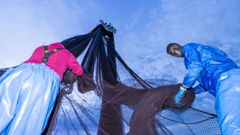 Dos trabajadores migrantes, descargando las redes en el puerto de Camarias, en una imagen de archivo. 