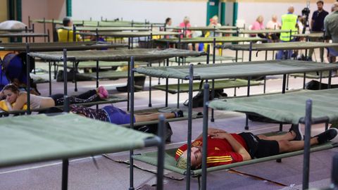 Los desplazados por el incendio forestal a Villa del Pardo, en Madrid, descansan en el pabell�n deportivo de Villamanta