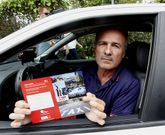 Manuel Chor�n muestra uno de los folletos que entregan a los turistas en el taxi. 