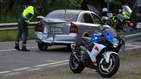 La moto en la que iba el guardia civil muerto y al fondo el coche contra el que choc 