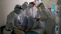 Sanitarios atienden a un paciente con coronavirus en la unidad de reanimaci�n (REA) del Complejo Universitario de Ourense, este mi�rcoles. Agotados pero al pie del ca��n un d�a tras otro. As� est�n en cr�ticos. No en vano, es la mejor definici�n del estado de �nimo de los profesionales sanitarios que lidian con los contagios de la covid-19, tanto desde Cuidados Intensivos (UCI) como en REA. 