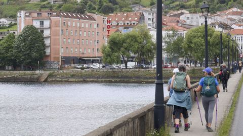El edificio, con cinco alturas en la parte más elevada, es lo primero que ven quienes llegan a Pontedeume por la ponte da Pedra (en la imagen, varios peregrinos)
