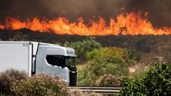 Un cami�n conduce por la autopista A7 mientras el incendio avanza en Los Gallaros
