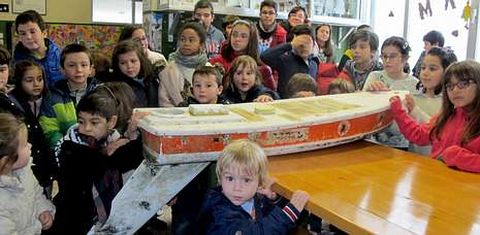 Los alumnos de O Pindo posan con el barquito que ha llegado desde Maine. 