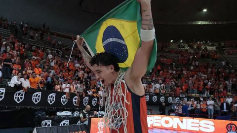 Caio Pacheco posa con la bandera brasile�a y las redes de una de las canastas tras lograr el ascenso a la Liga Endesa.