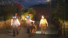 Uno de los dos heridos, el que pudo llamar para avisar y montar el dispositivo de rescate, es acompaado junto a su perro por los agentes hasta la ambulancia