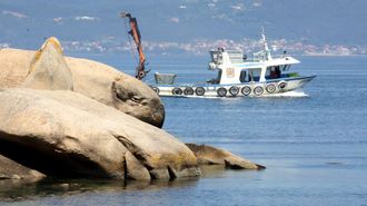 Un barco trabaja en un pol�gono de bateas de mejill�n en A Illa de Arousa.