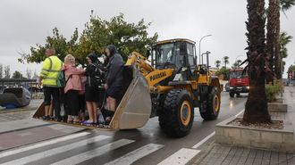 Un grupo de personas, el lunes en Oliva tras ser rescatadas con una excavadora.