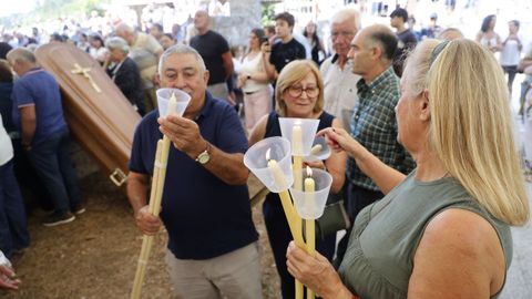 Los feligreses encendiendo cirios antes del inicio de la procesi�n en el costado de la Iglesia.