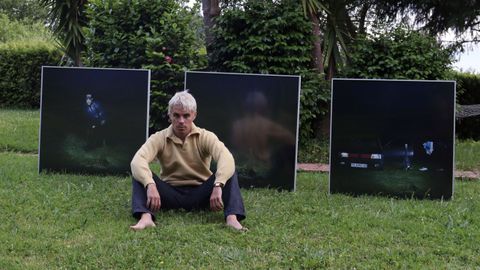 Sen Senra posando delante de las portadas de la triloga PO2054AZ, cuyo ttulo alude a la matrcula del viejo coche de su padre.