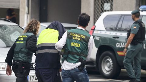 Agentes de la Guardia Civil, llevando al asesino confeso del crimen de Elisa Abruedo tras detenerlo en su puesto de trabajo.