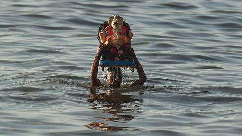 Un devoto traslada una imagen del dios Ganesh durante el festival Ganesh Chaturthi, en Bombay