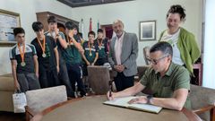 El presidente del club, Emilio Dieste, firma el libro de visitas ante el alcalde, Jos Carlos Vidal, la concejala Patricia Lojo y los remeros que se proclamaron campeones.