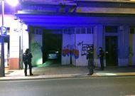 Agentes de la Polic�a Nacional comprobando el portal destartalado y el coche en el interior del garaje. 