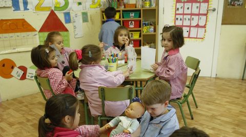 Arriba, los alumnos de 4 aos colocan unas pegatinas en las fichas mientras los de 5, en primer plano, juegan.