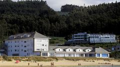 En primer plano, a pie de playa, el albergue viveirense de Area