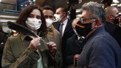 La candidata del PP, Isabel D�az Ayuso, ense�a una pluma que le regalaron este jueves durante un acto en la estaci�n de metro de Villaverde