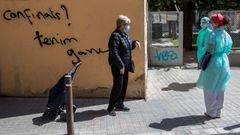 Dos enfermeras de atenci�n domiciliaria charlan con una vecina en el barcelon�s barrio del Raval