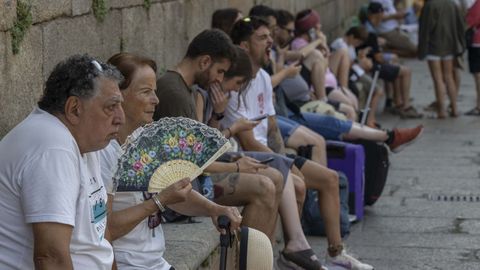 Los turistas buscan refugio del calor guareciéndose a la sombra de los edificios en Santiago.