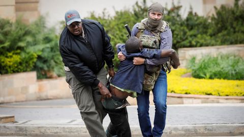 Agentes de seguridad trasladan a un herido tras el tiroteo y la explosi�n en el hotel