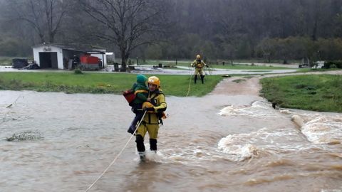 Los bomberos evac�an a una familia aislada por el agua en el concejo de Pilo�a en inmediaciones del paso a nivel de Reboira.