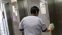 Una limpiadora desinfecta los ascensores de un centro de salud vigu�s